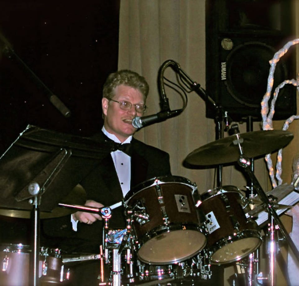 Energetic live band performance on stage with dynamic lighting at night.